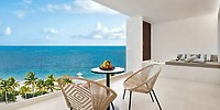 Elegant balcony featuring two chairs, fresh fruit, and a stunning ocean view—perfect for a romantic destination wedding stay at Majestic Mirage Costa Mujeres.