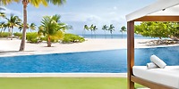 A poolside cabana at Majestic Mirage Costa Mujeres offers a stunning spot for a destination wedding, overlooking a tropical beach and the clear blue water.