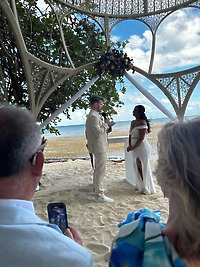 Aubrey and Noah exchanged their wedding vows on a sandy beach beneath a beautiful canopy, while guests looked on during their stunning destination wedding.