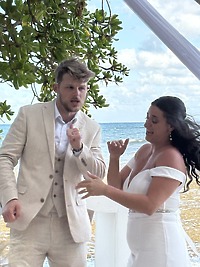 Aubrey and Noah dancing together outdoors beneath a canopy by the ocean at their destination wedding.
