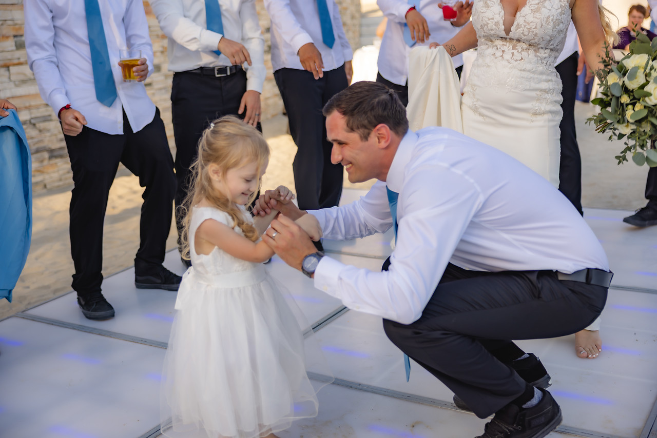 At the destination wedding, Jeff crouches to gently hold Camille’s hand, and they share a meaningful moment together.