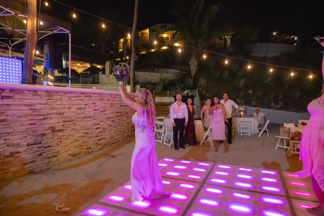 Camille and Jeff celebrate on the glowing dance floor at their destination wedding as the bride gets ready to toss her bouquet.
