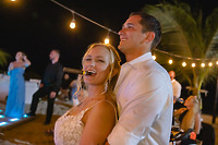 Camille and Jeff embrace beneath sparkling string lights at their enchanting outdoor destination wedding.