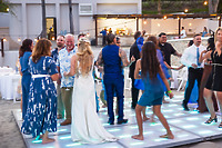 Guests dance beneath the stars on an illuminated floor during Camille and Jeff’s destination wedding reception.