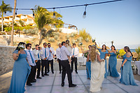 Camille and Jeff’s destination wedding celebration features their guests dancing outdoors in elegant blue attire beneath twinkling string lights.