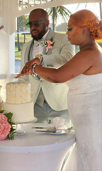 Cynthia and Ruben cut their white wedding cake together during an outdoor destination wedding ceremony.
