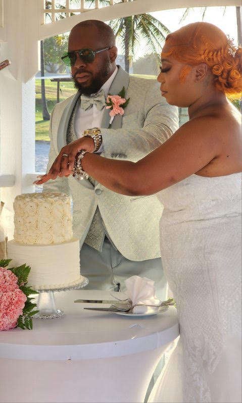 Cynthia and Ruben cut their white wedding cake together during an outdoor destination wedding ceremony.