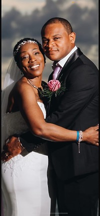 Natoya and Katrina, dressed in elegant formal attire, embrace and smile joyfully at their destination wedding.