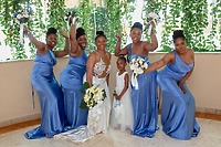 Khadijah and Oscar: At their destination wedding, the bride poses indoors with the flower girl and bridesmaids dressed in blue, all holding beautiful bouquets.