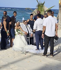 Jamie and Gary celebrate their destination wedding on the beach, surrounded by wedding guests by the ocean.