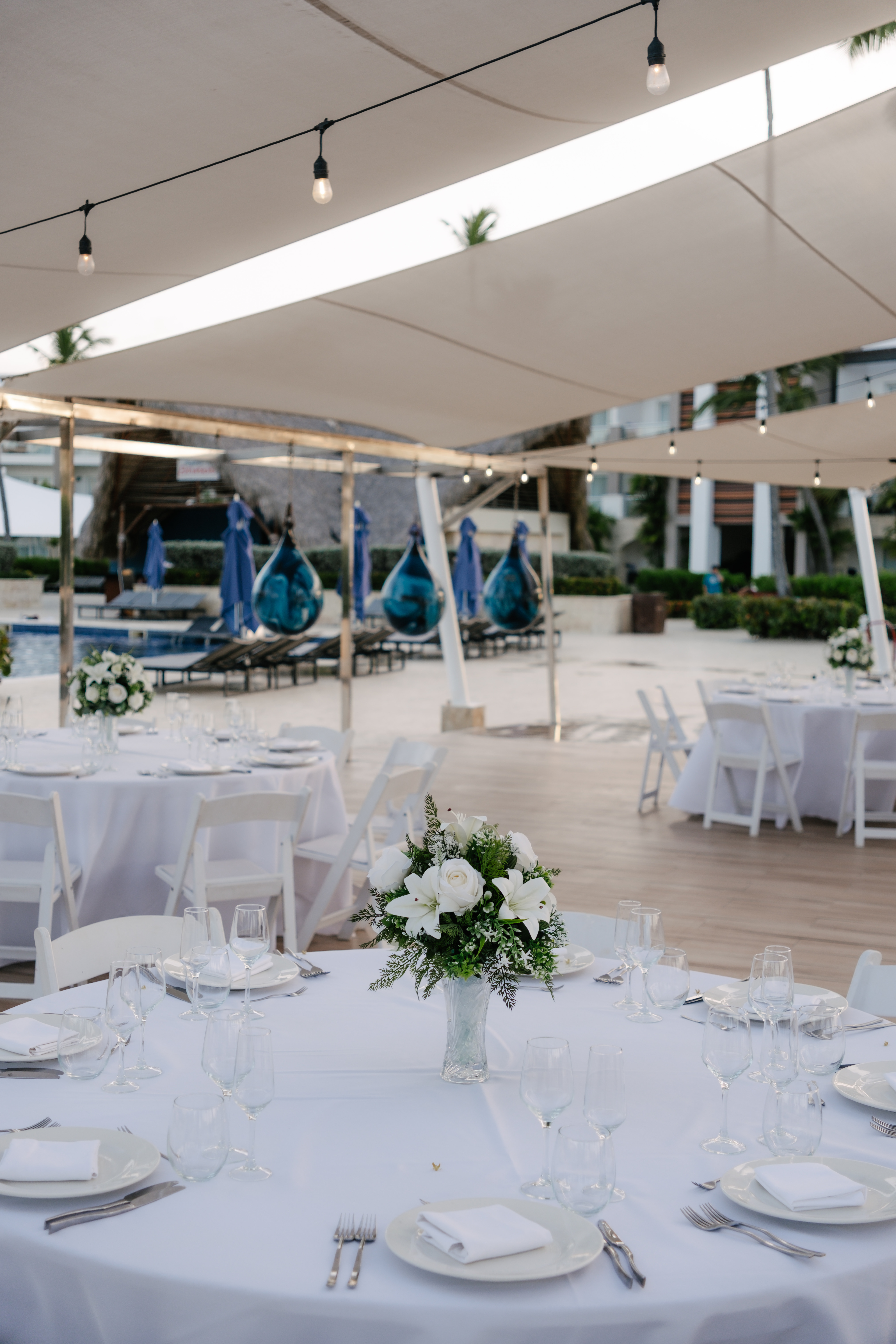 Kelsie and Matthew’s destination wedding featured elegant outdoor dining, with round tables adorned in white linens and beautiful floral centerpieces.