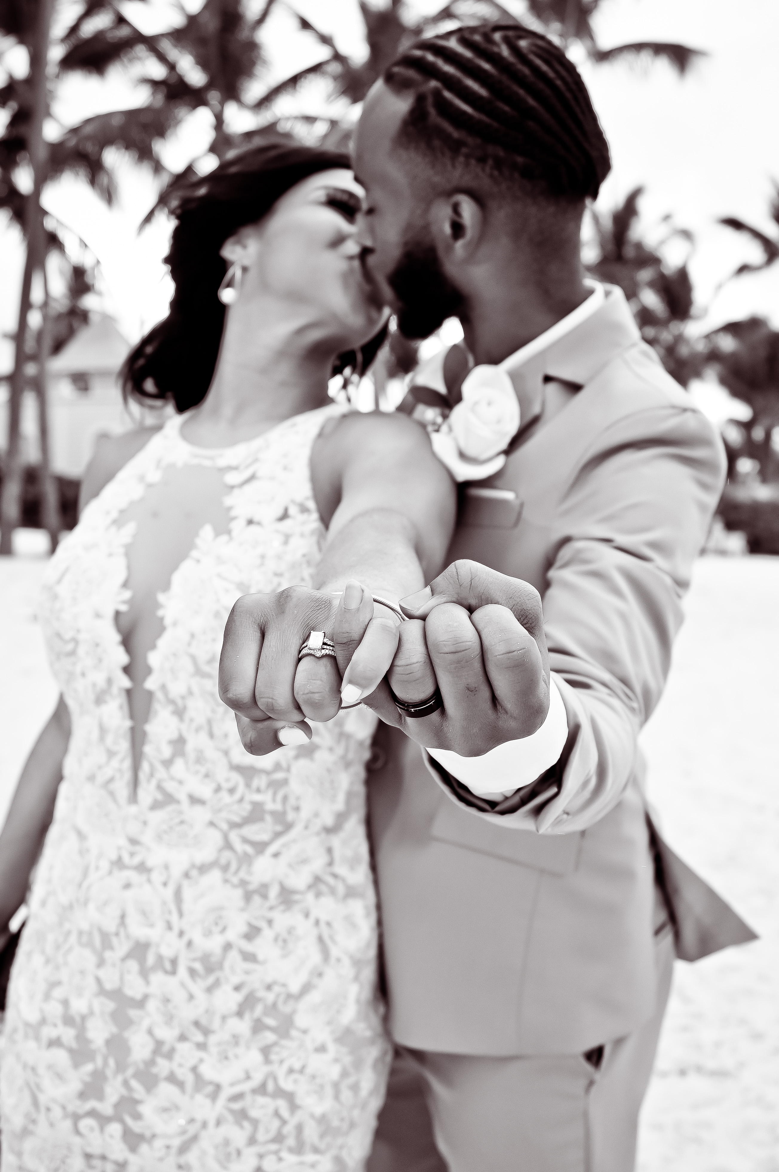 Trey and Kimberly share a kiss on the beach, proudly displaying their wedding rings to the camera during their destination wedding.