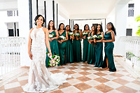 At a destination wedding, the bride in white stands with her bridesmaids dressed in green, all holding bouquets—Trey and Kimberly.