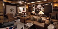 A cozy lounge at Moon Palace Nizuc, perfect for a destination wedding, featuring leather sofas, elegant armchairs, soft lamps, and warm wood-paneled walls.