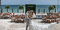 Bride and groom sharing their first dance at their destination wedding at Ocean Maya Royale, surrounded by beautiful ocean views and elegant beachside reception tables.