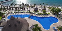 Aerial view of the Ocean Coral and Turquesa resort pool, featuring lounge chairs along a sandy beach—an idyllic setting for a destination wedding.