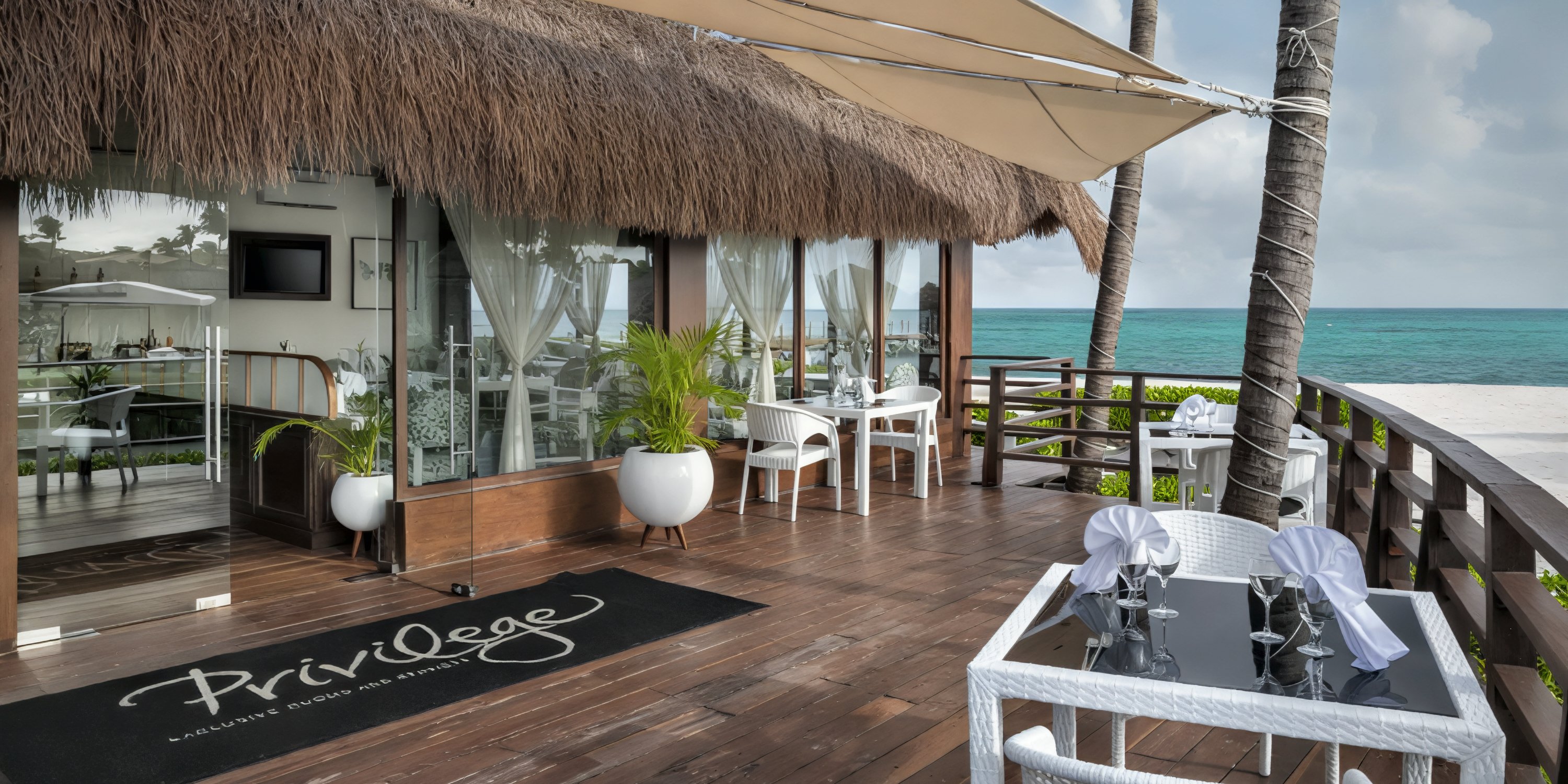 Ocean Coral and Turquesa: The perfect destination wedding venue, featuring outdoor dining under a charming thatched roof, elegant glass doors, and breathtaking ocean views.