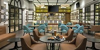 The Ocean Coral and Turquesa lounge bar offers a stylish setting perfect for a destination wedding, featuring round tables, elegant blue chairs, and a variety of food and drinks for your celebration.