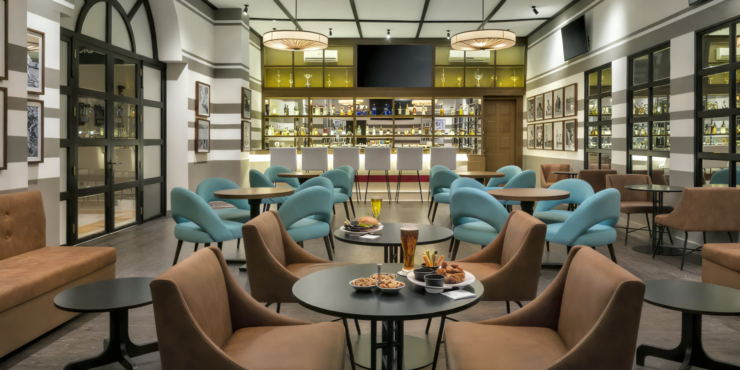 The Ocean Coral and Turquesa lounge bar offers a stylish setting perfect for a destination wedding, featuring round tables, elegant blue chairs, and a variety of food and drinks for your celebration.