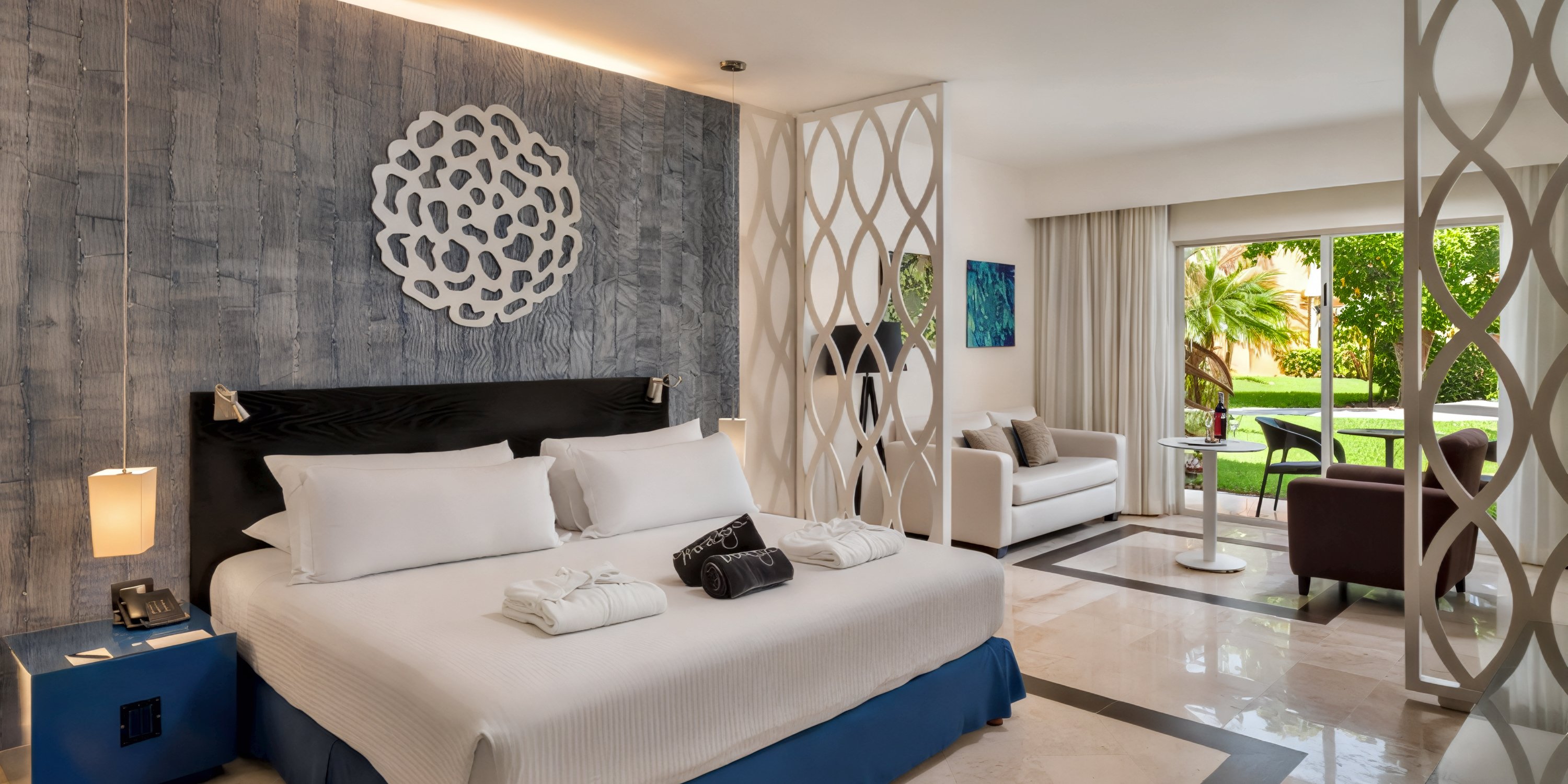 Ocean Maya Royale room: Perfect for a destination wedding stay, this inviting space offers a king bed, cozy seating area, and picturesque garden views through large windows.