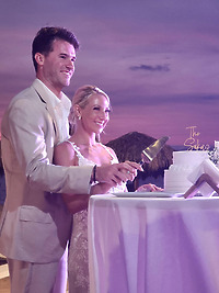 Leah and Christopher cut their wedding cake together during an outdoor evening celebration at their destination wedding.