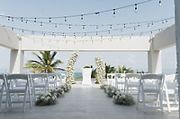 Brittiney and Franswa (Copy): Stunning outdoor wedding ceremony featuring white chairs, beautiful florals, and romantic string lights—perfect for a destination wedding atmosphere.