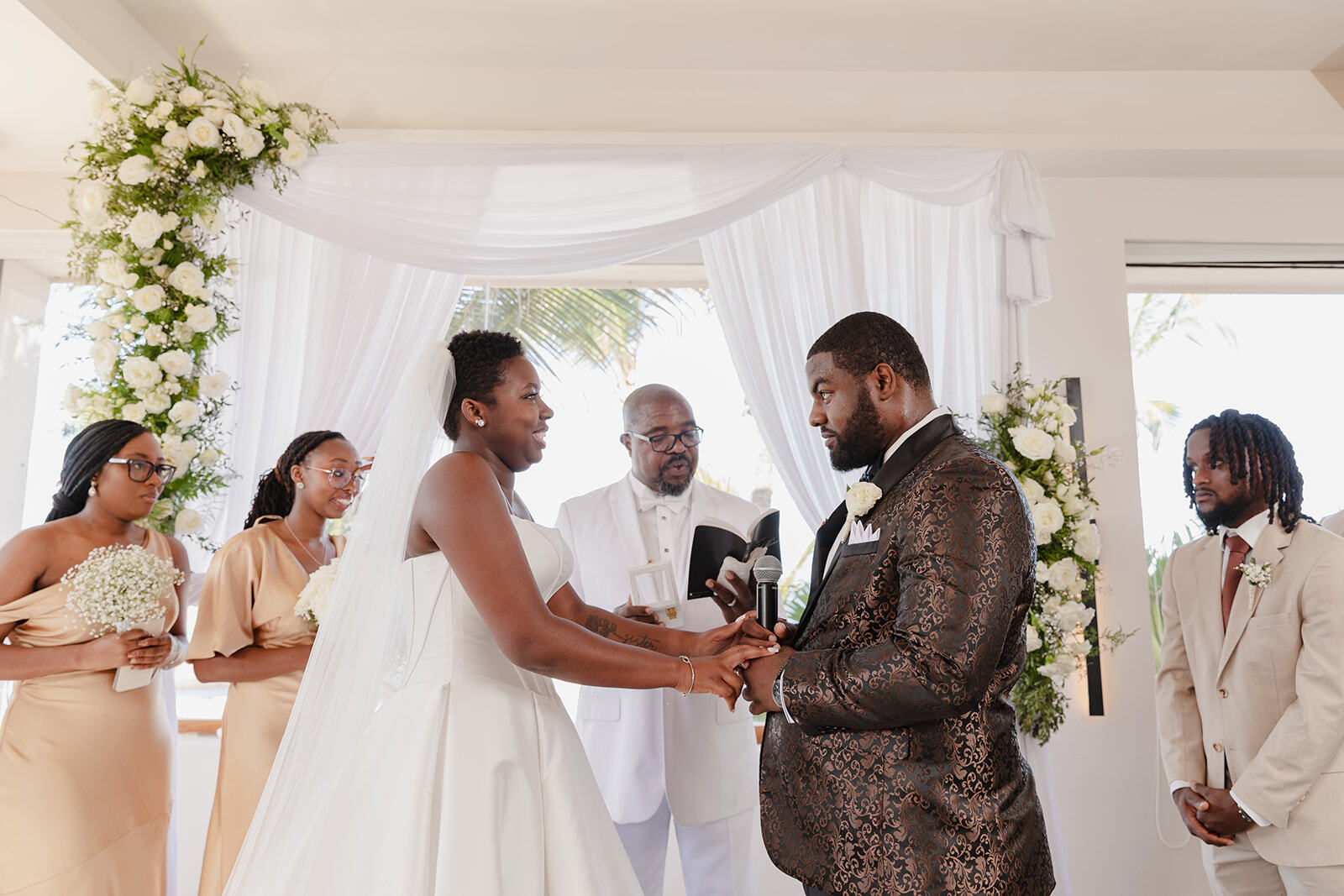 Jordan and Kievan exchange vows at their destination wedding, surrounded by their bridal party and officiant.