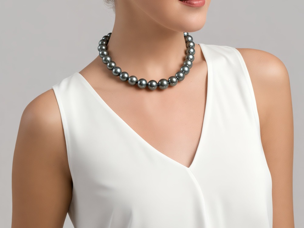 A woman at a destination wedding wears a strand of large black pearls paired with a sleeveless white top.