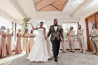 Saphire and Stephen walk down the aisle to enthusiastic applause from their wedding party, the sunlight streaming into their beautiful destination wedding venue.