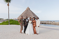 Five in formal wear pose by the ocean at a destination wedding, showcasing Jordan and Kievan attire.