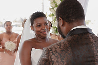 Jordan and Kievan stand together at their destination wedding, bridesmaids lined up in the background.