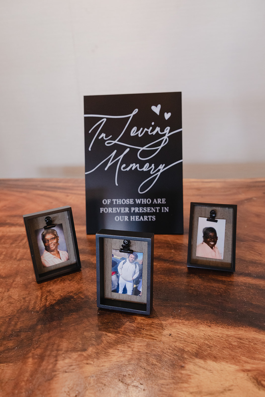 A destination wedding memorial display for Jordan and Kievan, with framed photos and "In Loving Memory" sign.