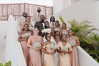 Saphire and Stephen's wedding party gathers on the stairs, featuring champagne-clad bridesmaids and groomsmen in sleek suits—capturing a picture-perfect moment from their destination wedding.