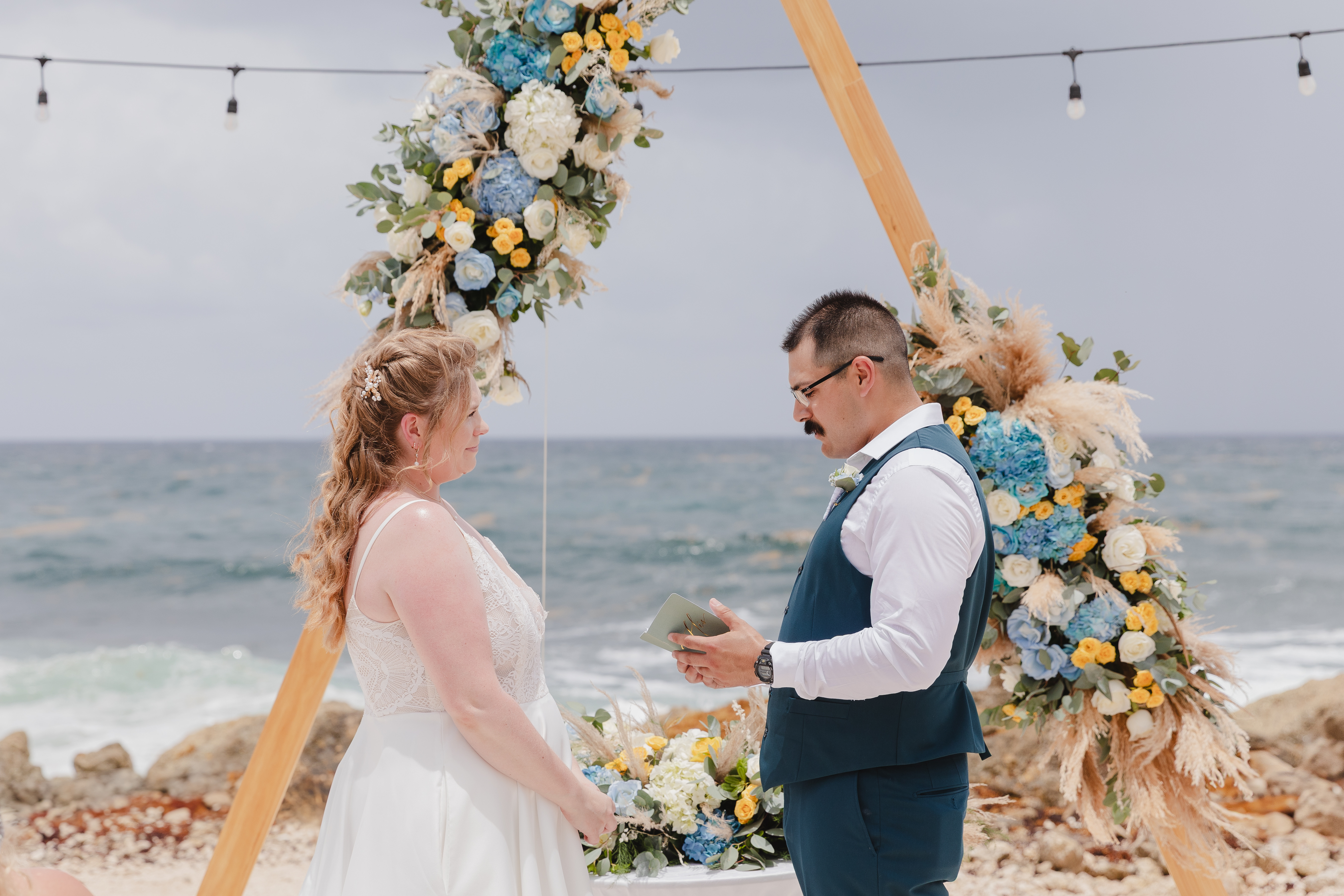 Teneal and Jonathan exchange vows during a stunning outdoor beach destination wedding ceremony.