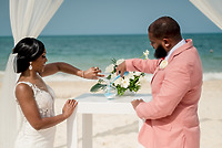 Sydney and Hayden (Copy) are featured as the couple pours sand during their beach wedding ceremony, adding a unique touch to their destination wedding celebration.