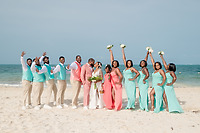 Sydney and Hayden’s destination wedding party celebrates on a sandy beach, with the sparkling ocean as their backdrop.