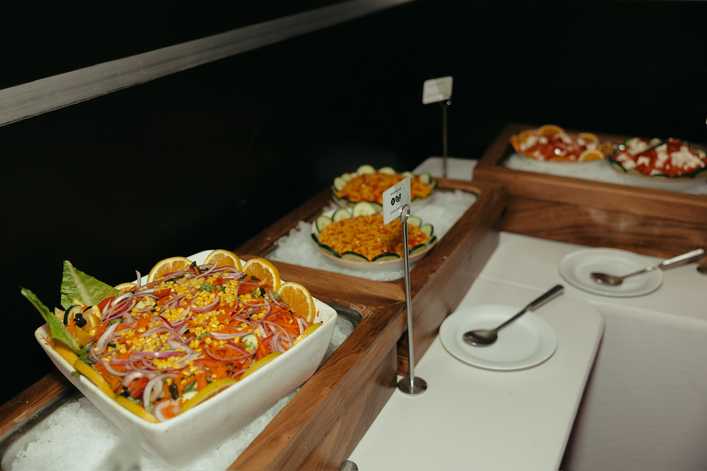 Stephanie and Mark’s destination wedding features a salad bar with bowls on ice and serving spoons.