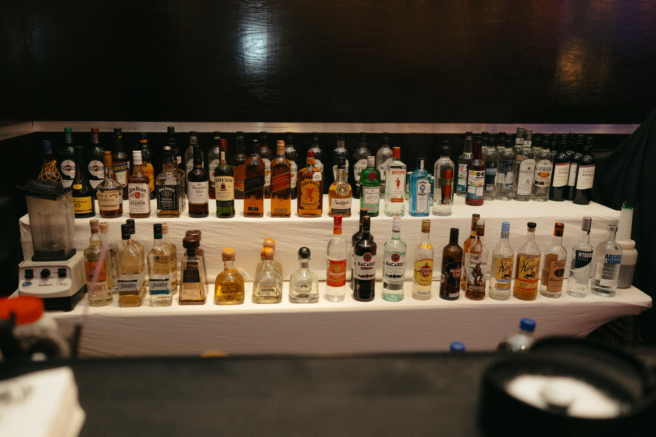 A photo of Stephanie and Mark’s destination wedding displayed on a two-tiered table behind the bar.