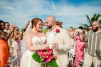 Mobolaji and Sylvia (Copy) smile with drinks at their destination wedding, surrounded by joyful guests outdoors.