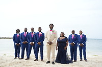 Kiah and Rodney (Copy): A destination wedding party gathers on a beach, with the ocean and sky creating a stunning backdrop behind them.