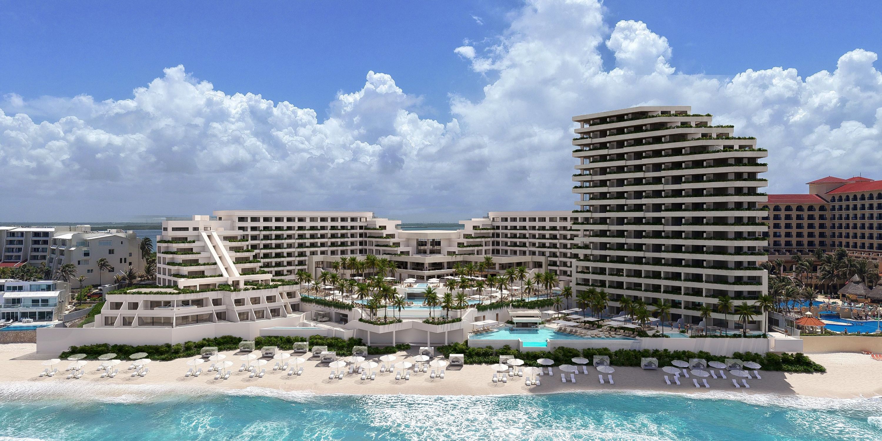 A modern beachfront resort complex perfect for a destination wedding, with pools, palm trees, and lounge chairs.