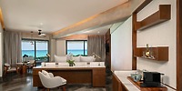 Elegant hotel suite perfect for a destination wedding, featuring ocean view, work desk, and coffee maker.
