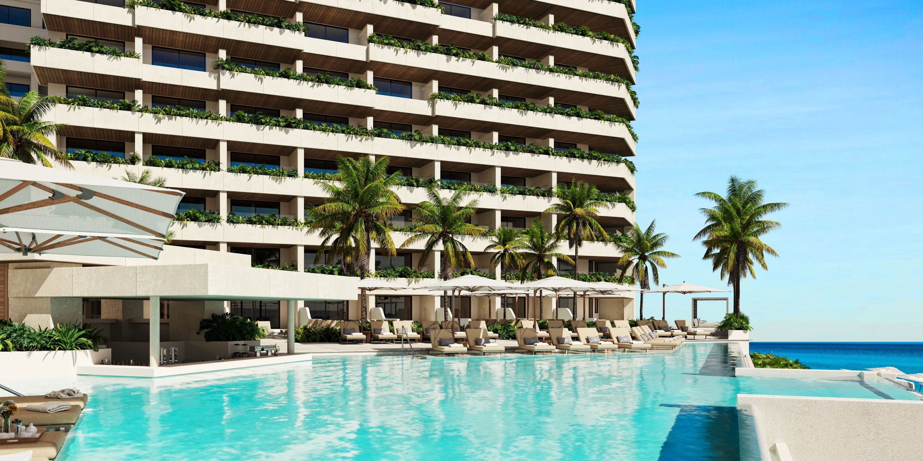 Modern hotel with palm trees, sun loungers, and a pool overlooking the ocean—a dream destination wedding.