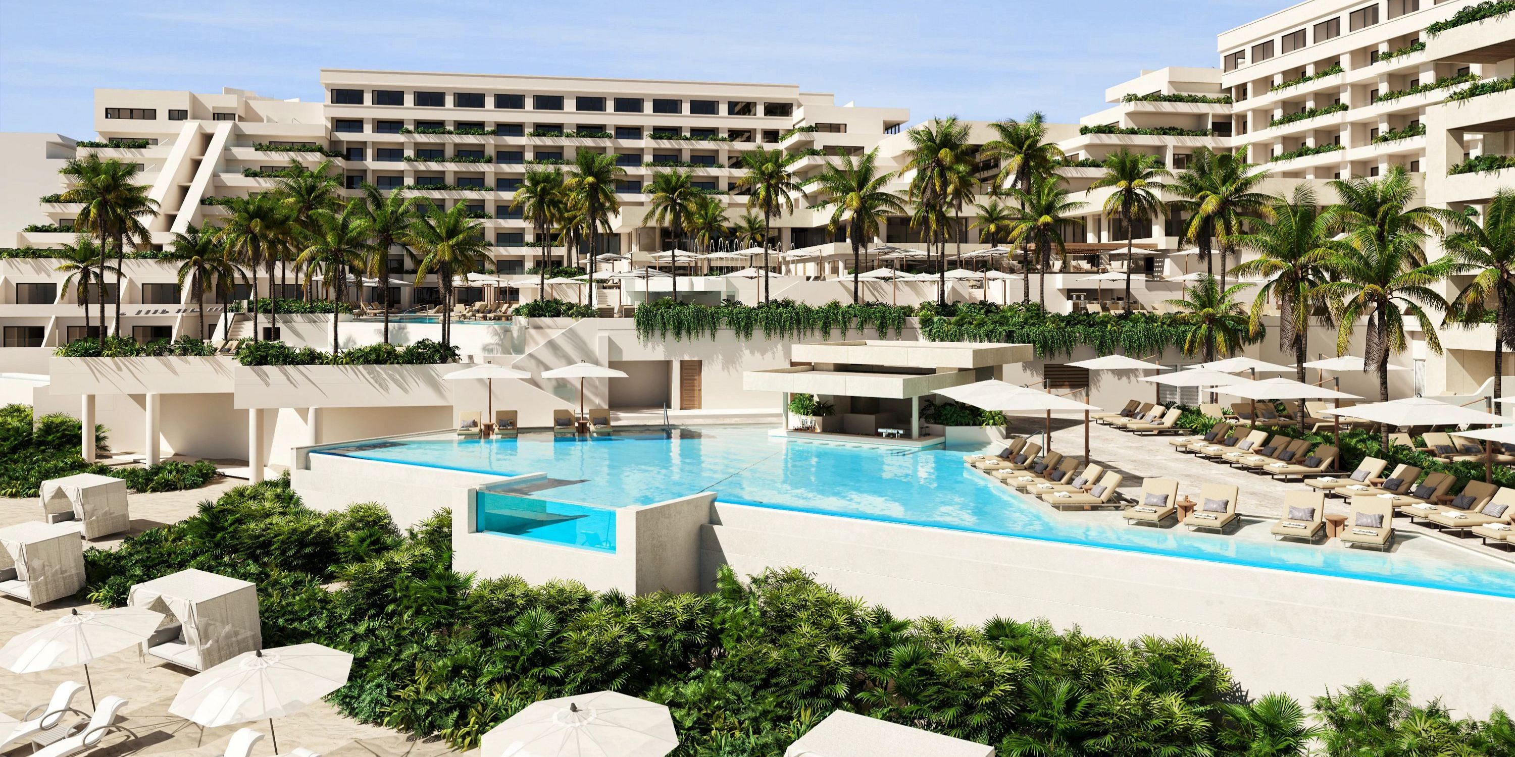 Modern resort ideal for a destination wedding, with pools, palm trees, lounge chairs, and white buildings.