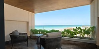Two chairs and a small table on an ocean-view balcony at a popular Cancun destination wedding resort.