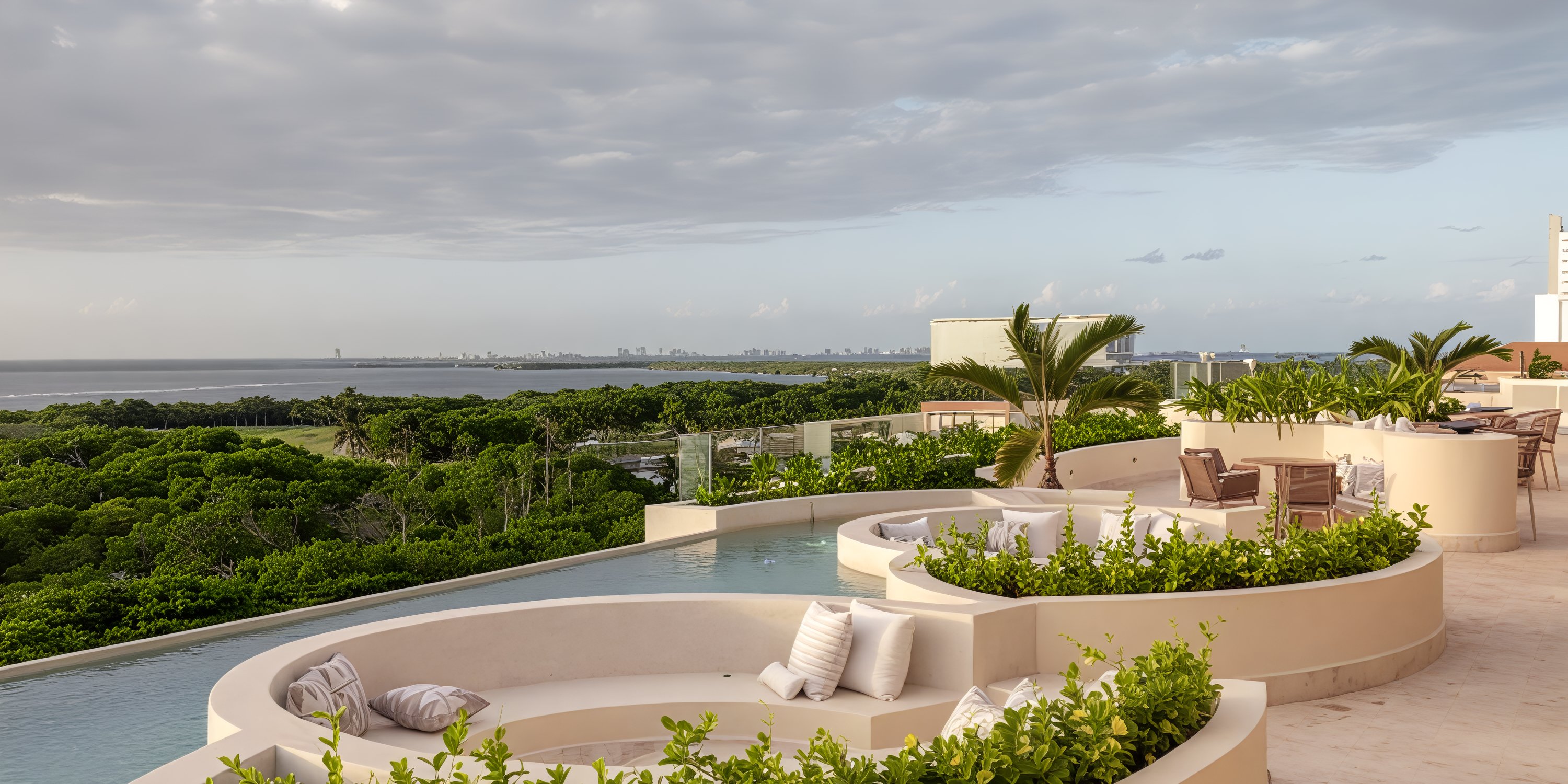 Curved poolside lounge with lush greenery, ideal for a destination wedding at Secrets Mirabel Cancun.