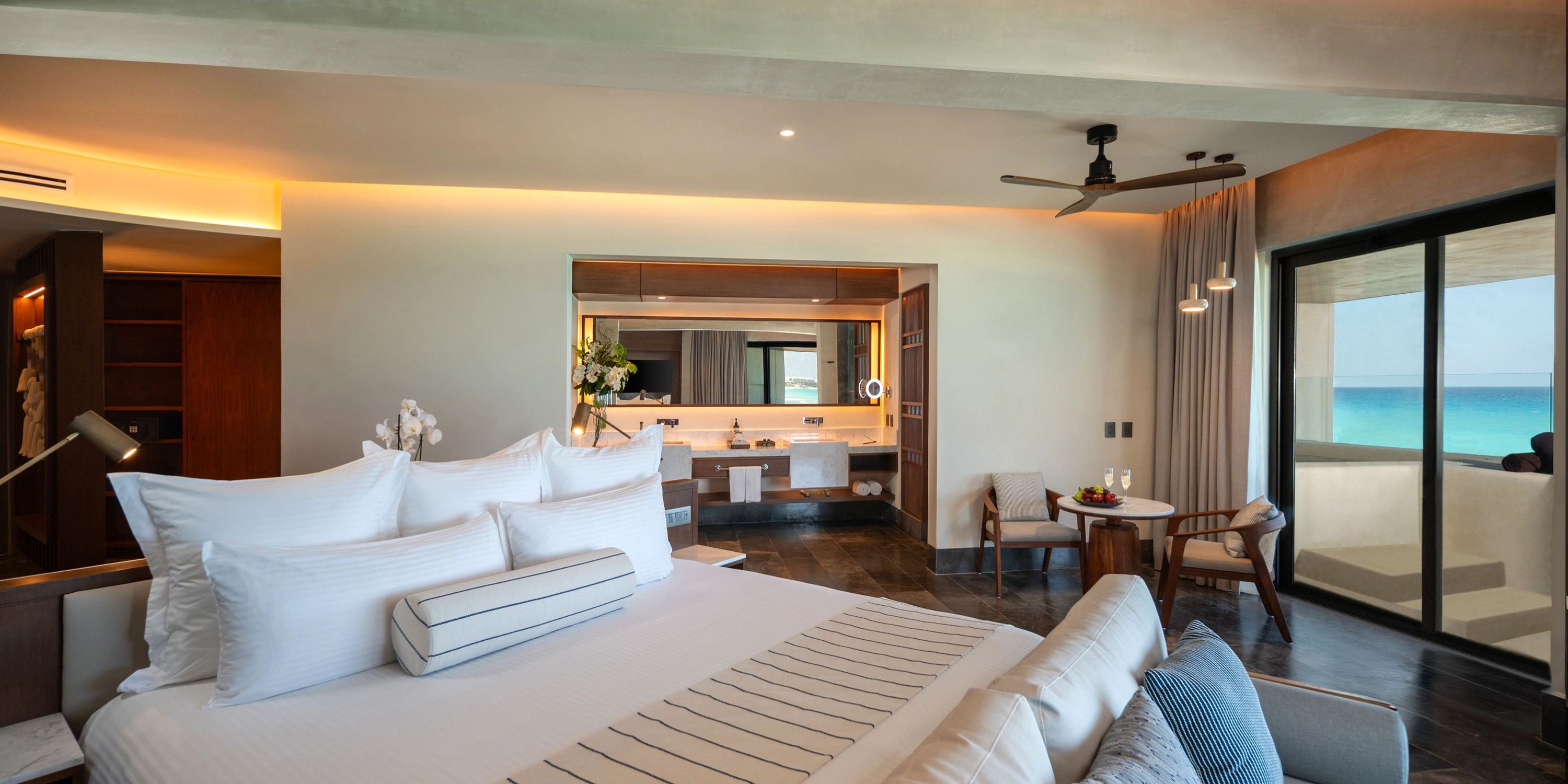 A cozy room with a bed, a sink, and a fan—perfect for guests at a destination wedding.