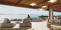 Open-air lounge ideal for a destination wedding, featuring cushioned seating, ocean view, wooden ceiling.