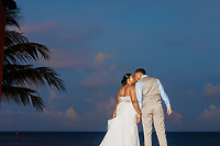 Jessie and Taylor share a kiss in wedding attire by the ocean at sunset during their destination wedding.