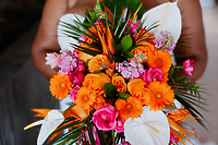 Person holding the Jessie and Taylor bouquet for a destination wedding with orange, pink, and white flowers.